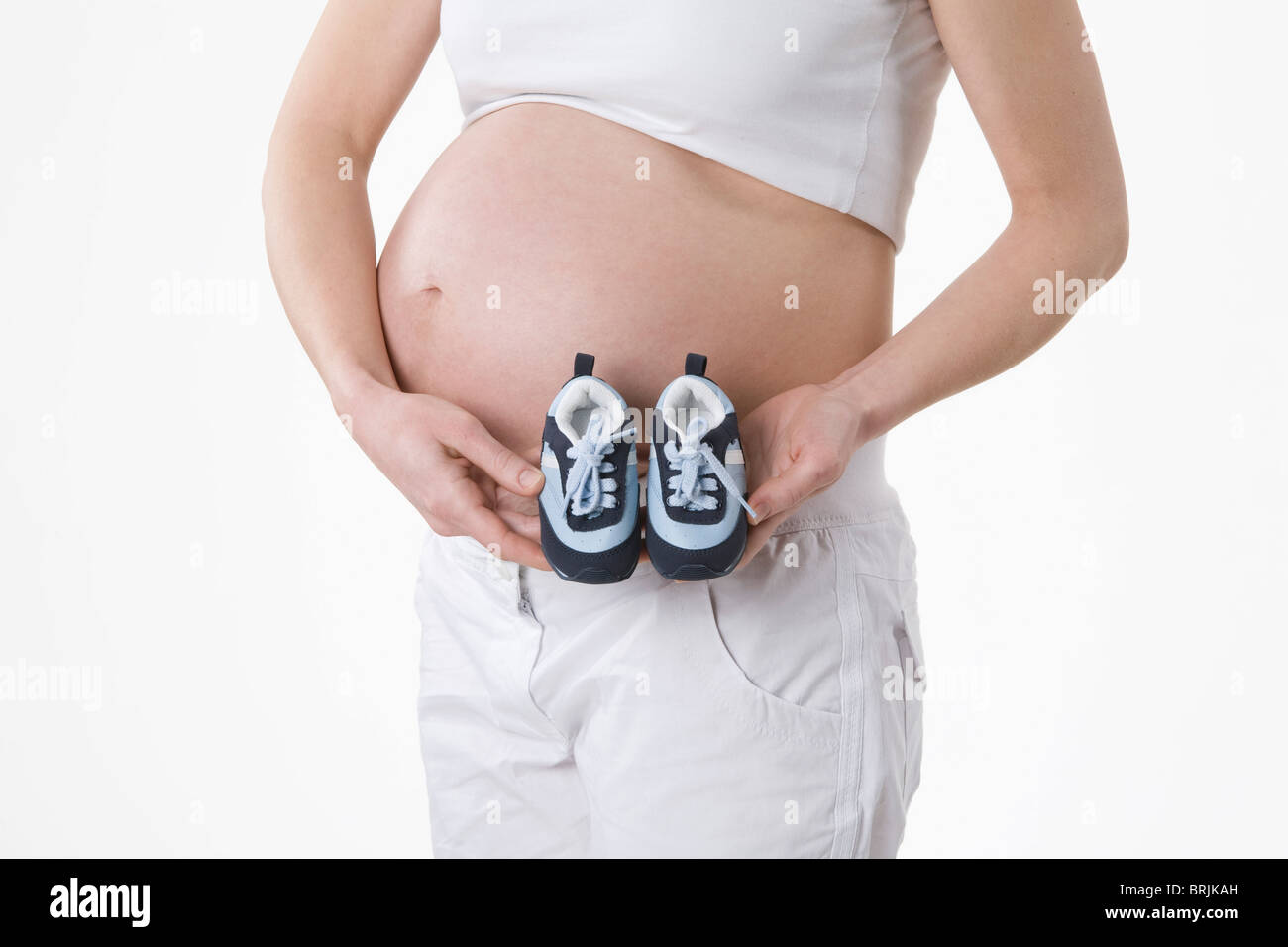 Schwangere Frau Holding Babyschuhe Stockfoto