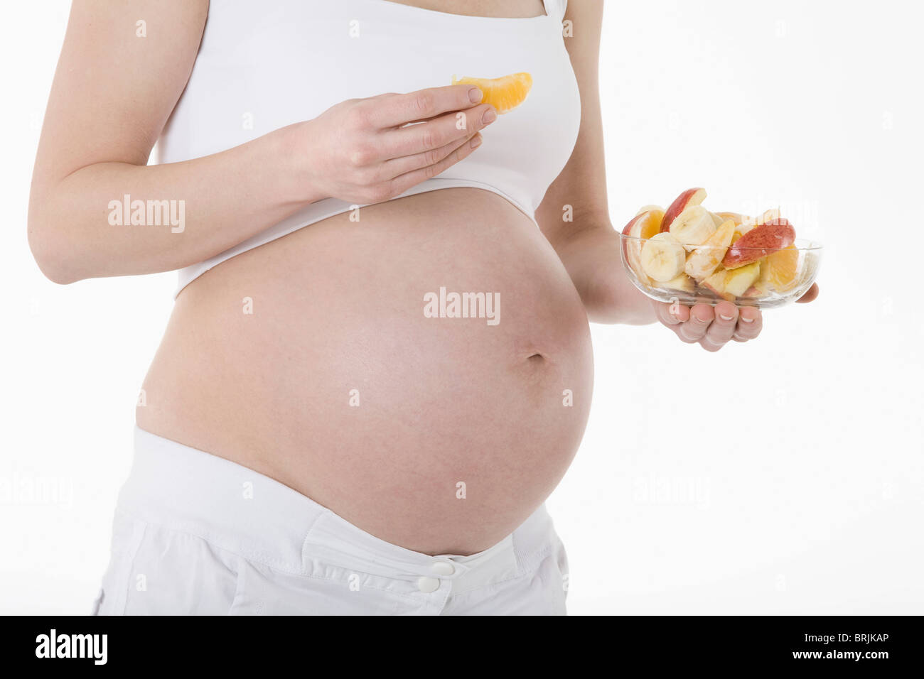 Schwangere Frau essen Obst Stockfoto