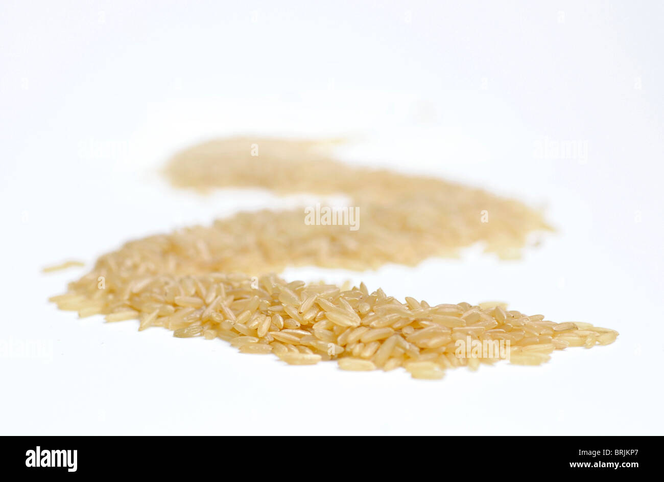 Haufen brauner Reis auf weißem Hintergrund Stockfoto