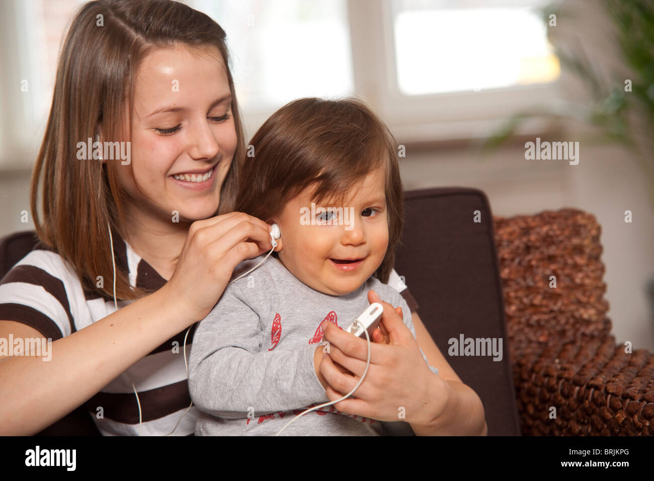 Teenager-Mädchen mit Baby Boy anhören von MP3-Player Stockfoto