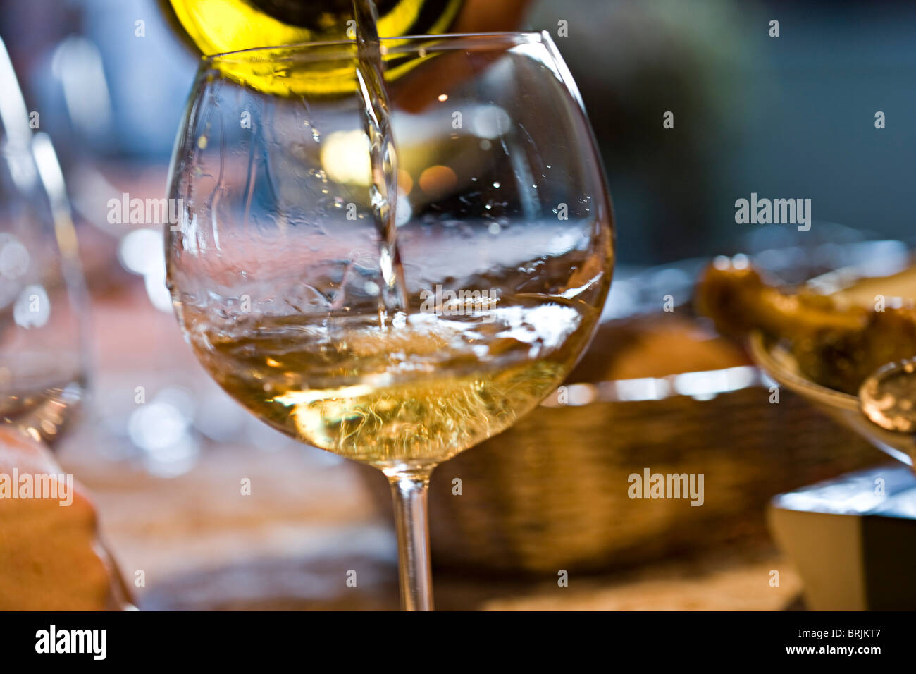 Glas Weißwein gießen Stockfoto