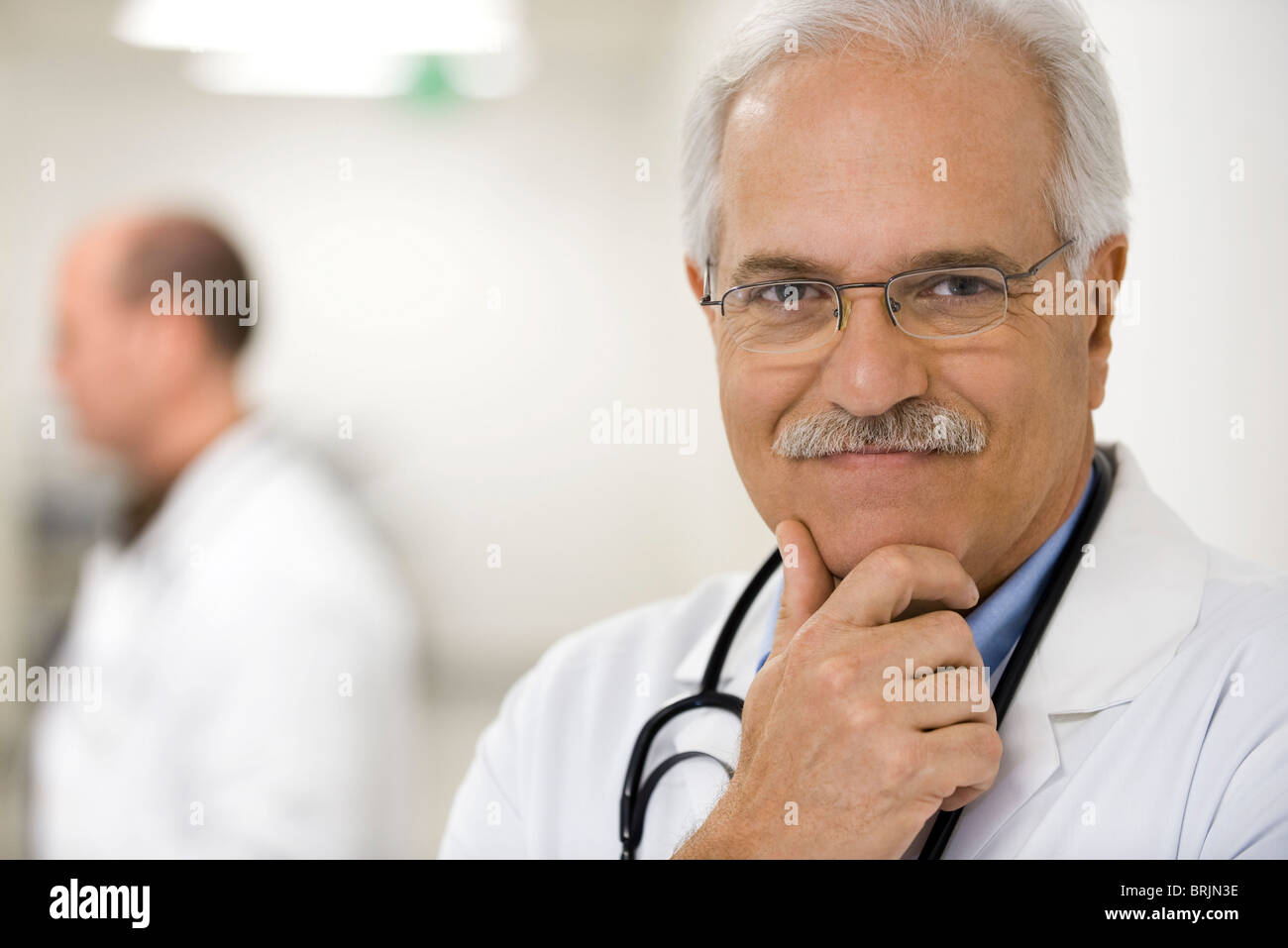 Arzt mit der Hand unter Kinn, Porträt Stockfoto