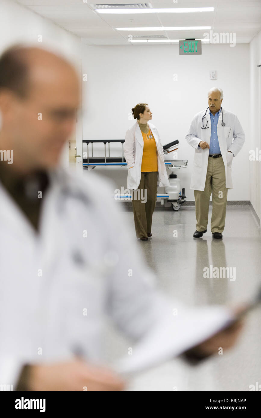 Ärzte zu Fuß hinunter Krankenhausflur Stockfoto