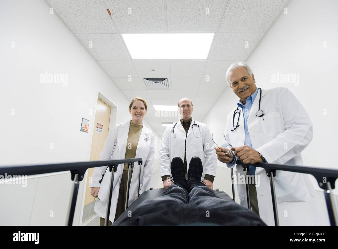 Ärzteteam blickte auf Patienten auf Bahre Stockfoto