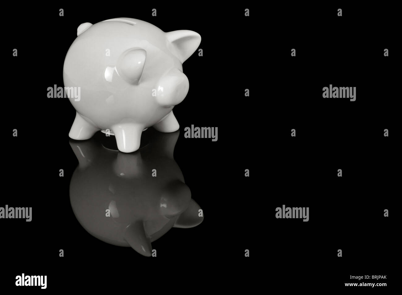Schwein geformt Spardose auf einer schwarzen reflektierenden Oberfläche, mit Platz für text Stockfoto