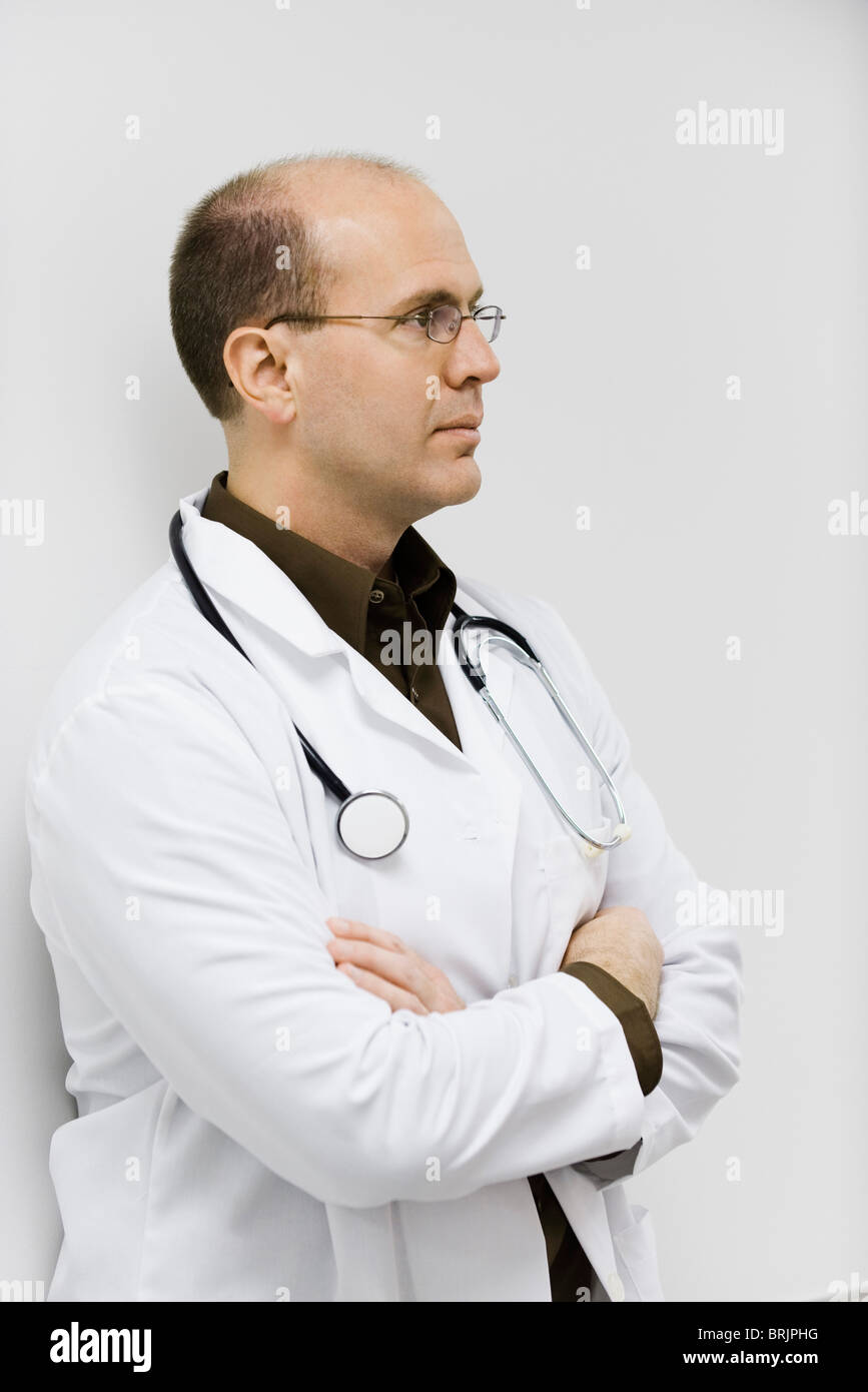 Arzt Wand gelehnt, verschränkt Arme, Porträt Stockfoto