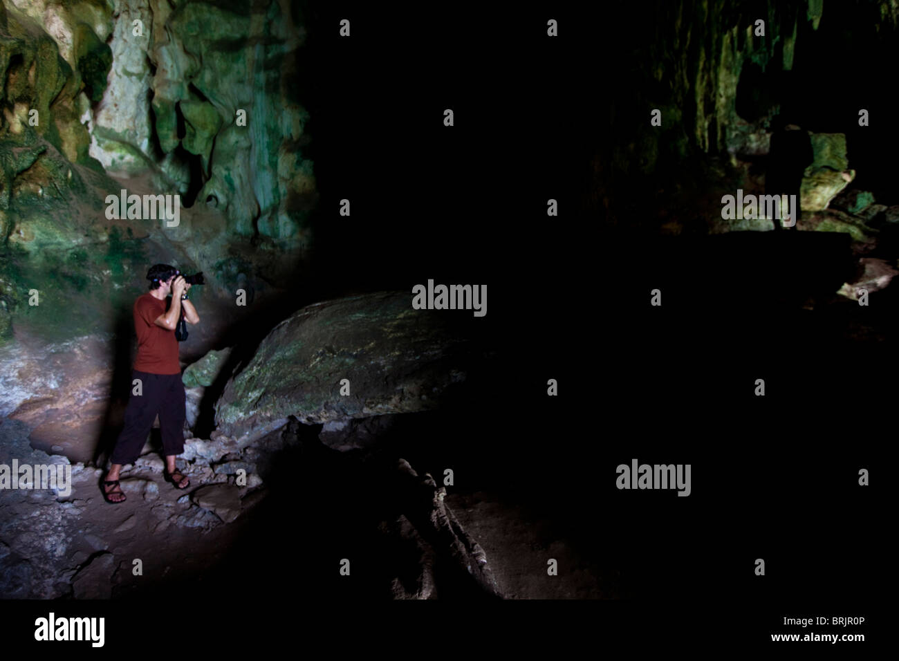 Männlichen Fotografen schießen einem abgedunkelten Thema in eine Tropfsteinhöhle in Thailand. Stockfoto