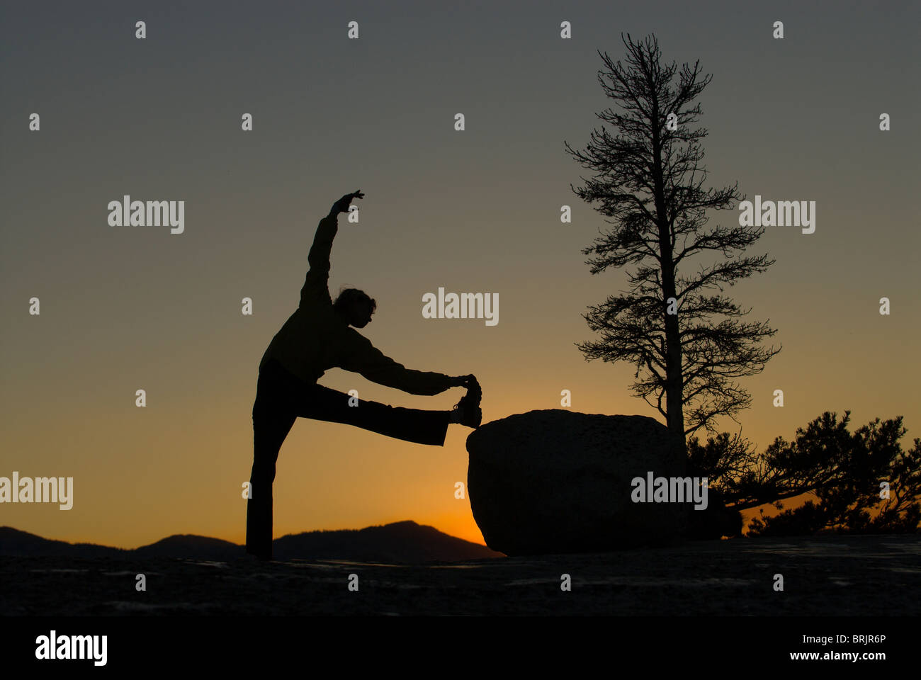 Eine junge Frau macht Yoga im Abendlicht. Stockfoto