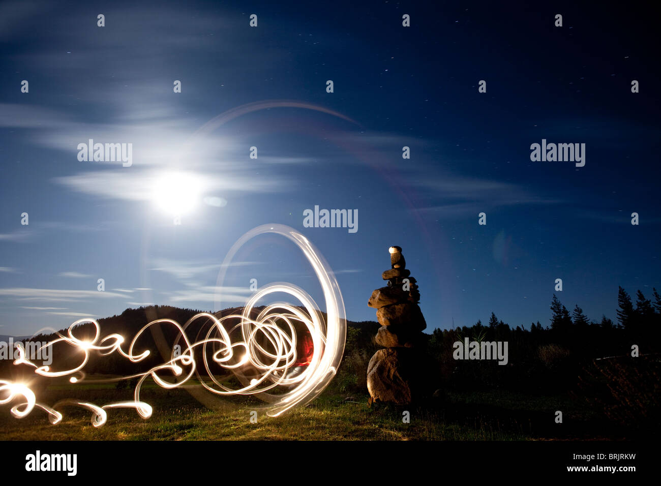 Rock Cairn mit Lightpainting neben ihm und Vollmond im Hintergrund in Idaho. Stockfoto