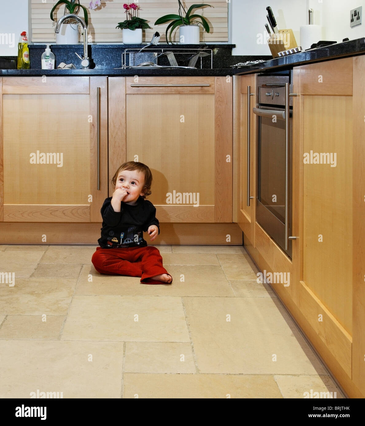 Baby auf modernen Küchenboden. Stockfoto