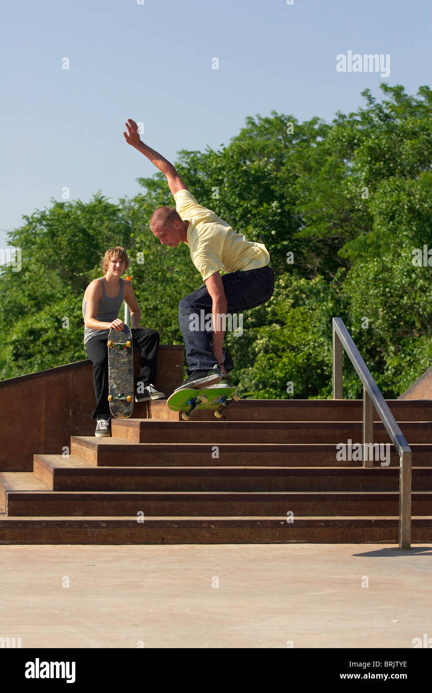 Zwei männliche Skateboarder Tricks von Treppe an einen Skate-Park zu machen. Stockfoto