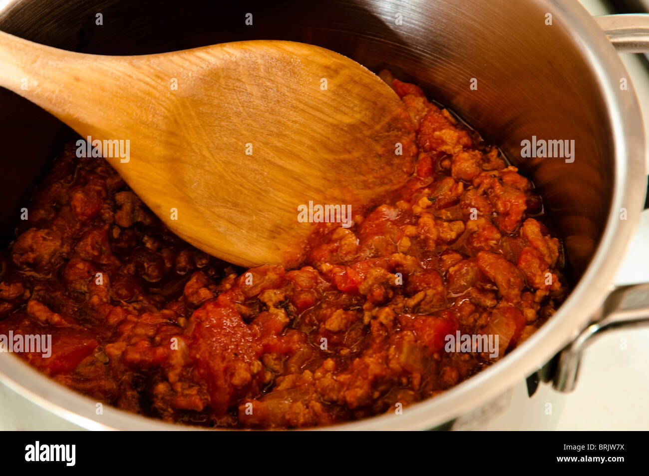 Eine klassische Bolognese-Sauce - machte vor allem aus Hackfleisch, Zwiebeln und Tomatenkonserven - mit einem Holzlöffel gerührt werden. Stockfoto