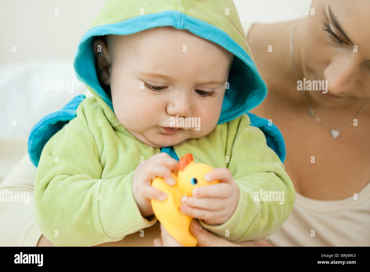 Baby spielt mit Gummiente vor dem Baden Stockfoto
