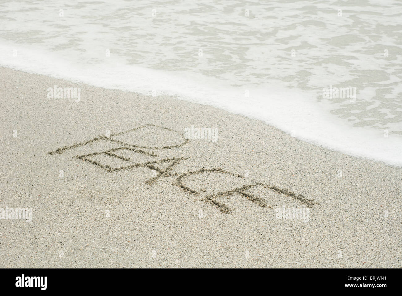 Das Wort "Frieden" in den Sand am Strand geschrieben Stockfoto