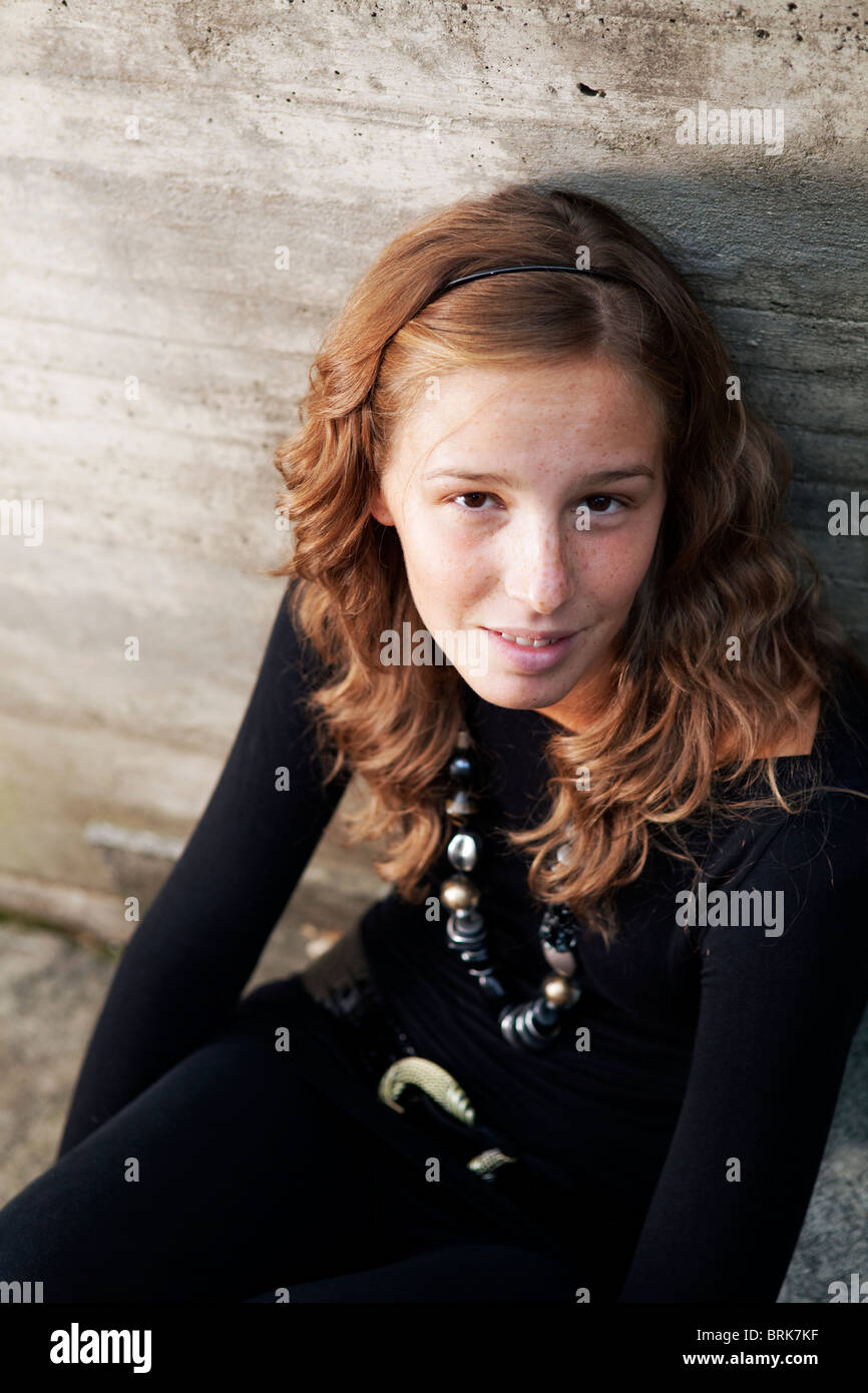Einsames Mädchen sitzen durch eine Betonmauer Stockfoto