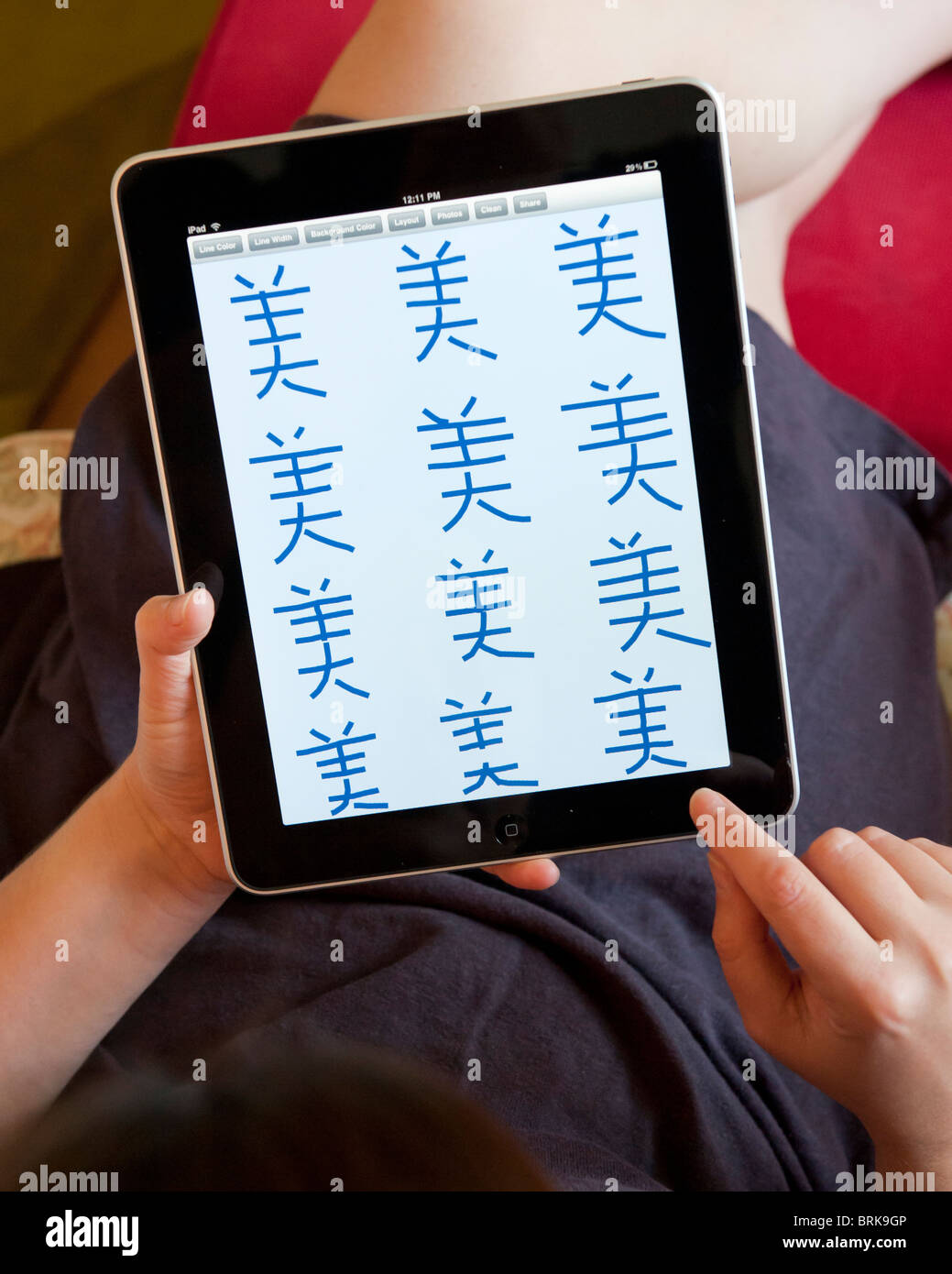 Frau, üben, um chinesische Schriftzeichen auf einem iPad Tablet-Computer schreiben Stockfoto