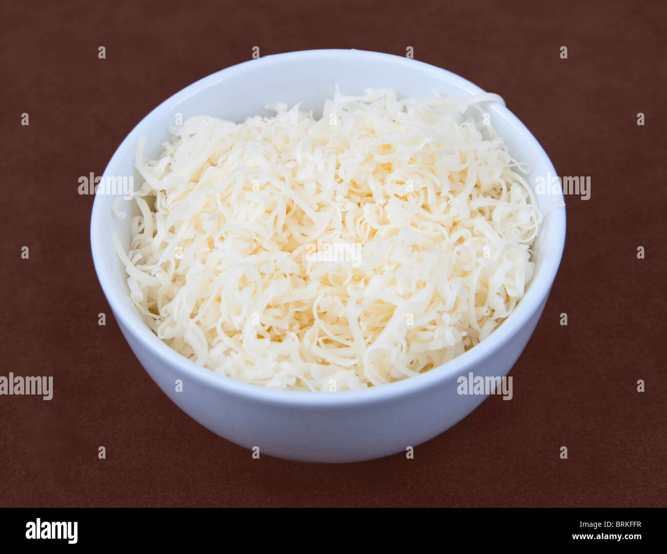 eine kleine weiße Prep Schüssel voll von geriebenem Käse zum Kochen bereit. Stockfoto
