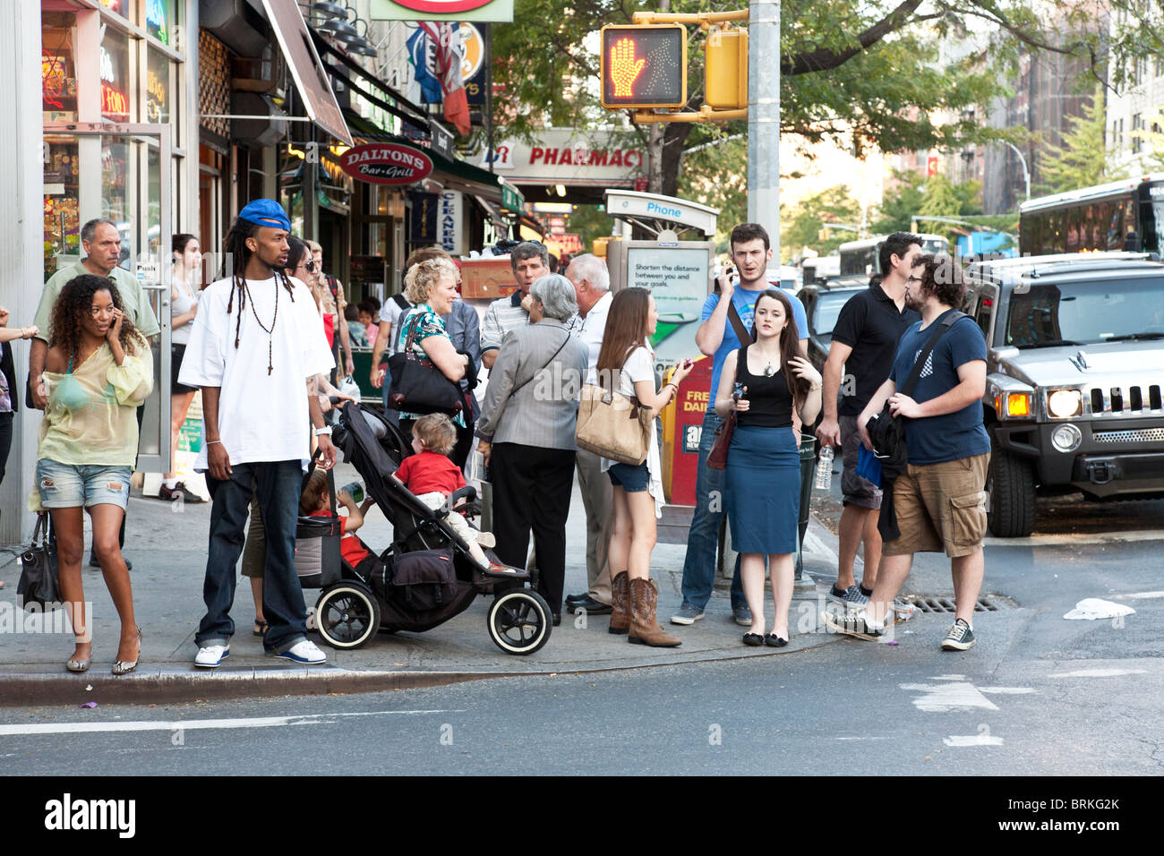 dynamische vielfältigen multikulturellen Haufen von New Yorkern, die darauf warten, überqueren Sie die Straße an einer neunten Avenue Straße Ecke Höllen Küche NYC Stockfoto