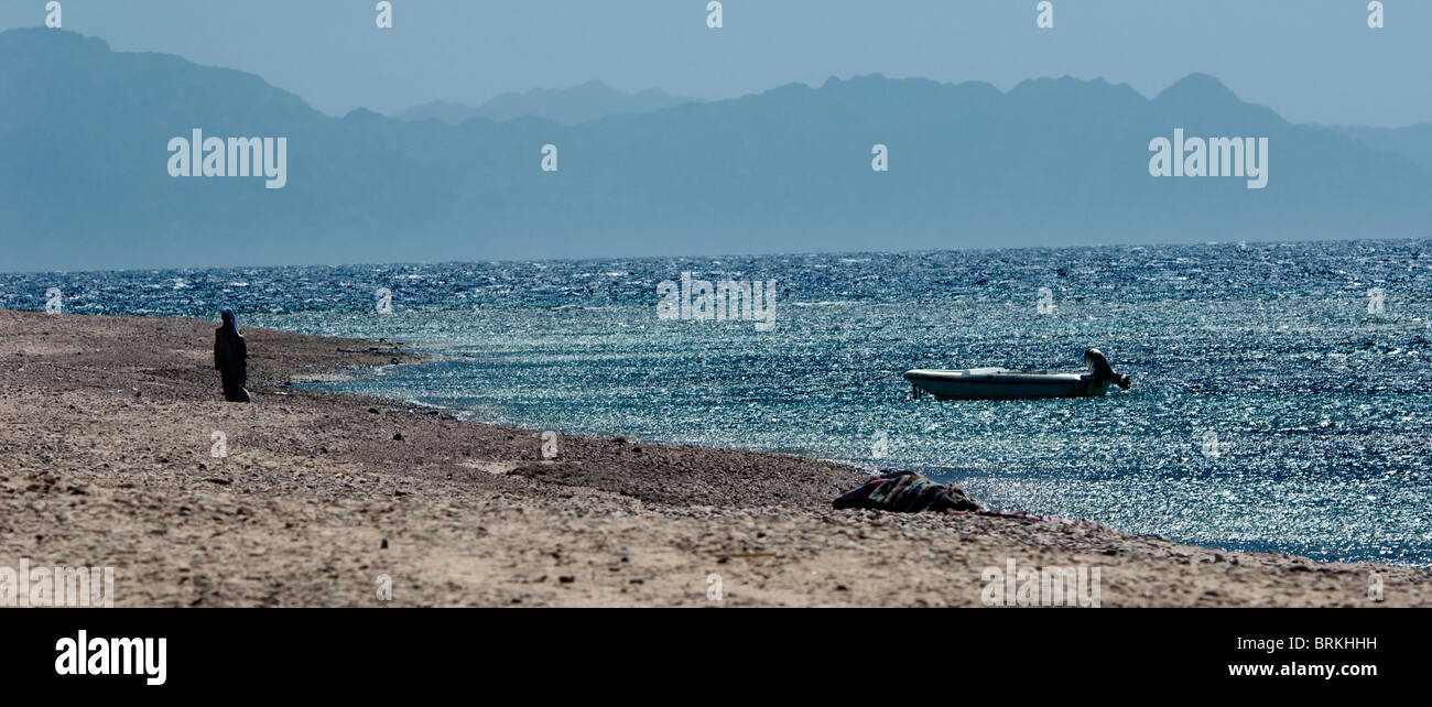 Einsame Beduinen Mann geht einen einsamen Strand Stockfoto