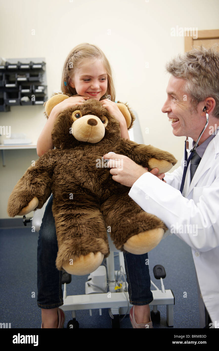 Arzt auf Teddy Bär Herz hören Stockfoto