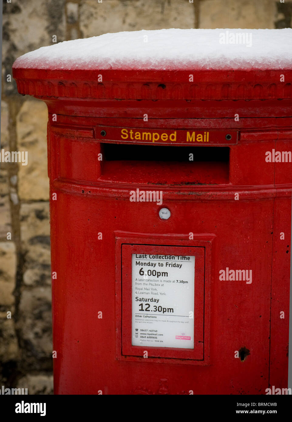 Nahaufnahme eines roten Postkastens von Royail Mail, bedeckt mit Schnee, Großbritannien Stockfoto