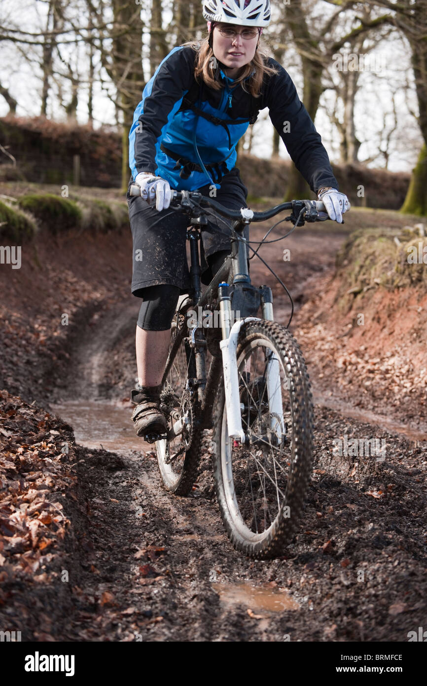 Frau Reiten Mountainbike schlammigen Strecke Stockfoto