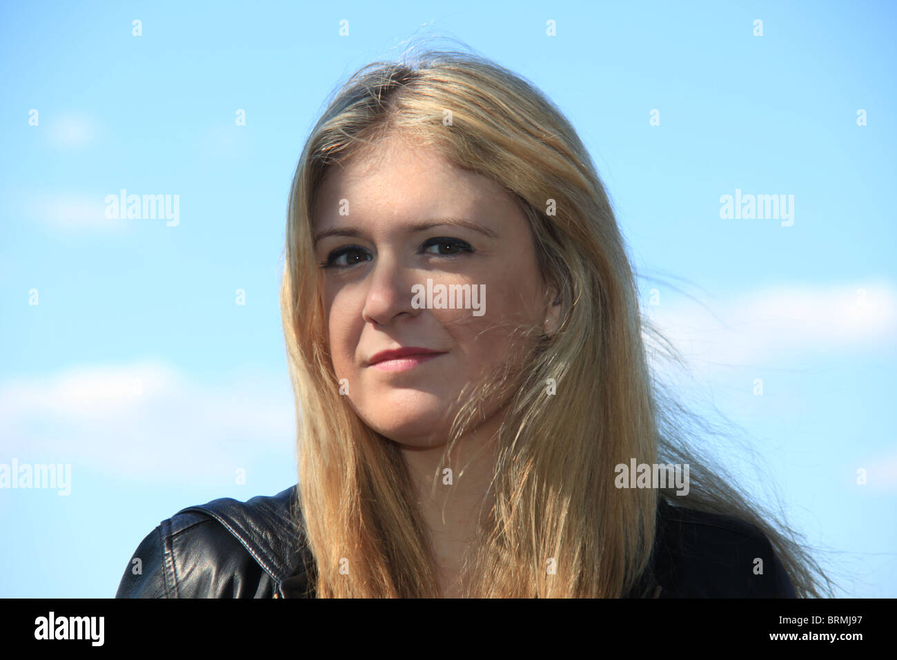 Attraktive junge blonde Frau posiert vor blauem Himmel, 2. Oktober 2010 Stockfoto