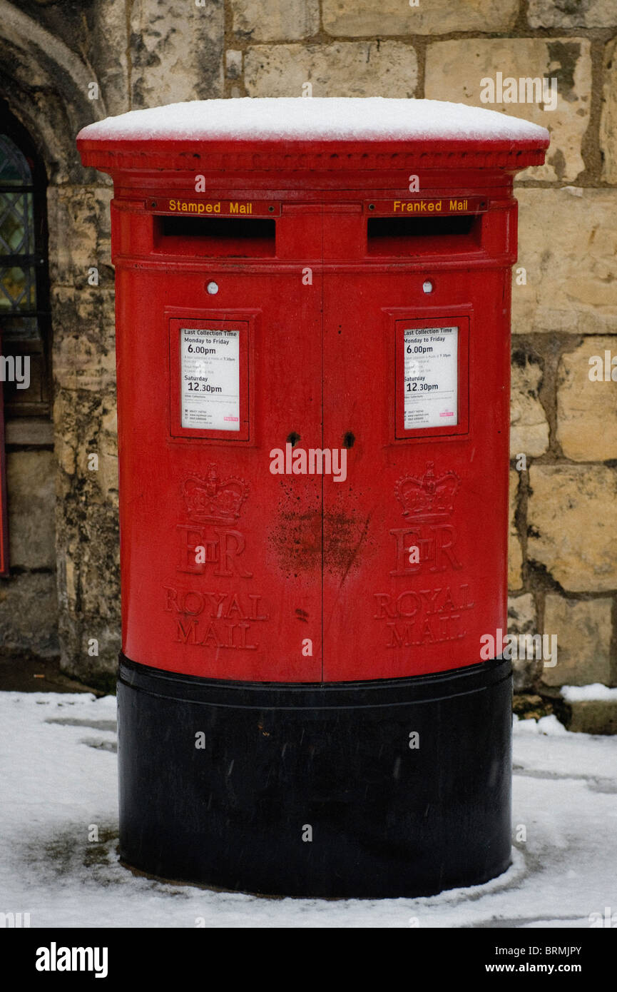 Schneebedeckte große rote Royal Mail Briefkasten mit 2 Steckplätzen, einer für frankierte Post und einer für frankierte Post. VEREINIGTES KÖNIGREICH Stockfoto