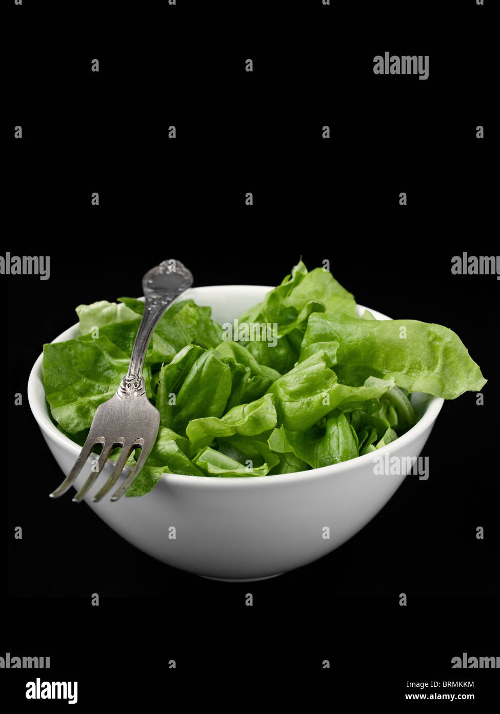 Grüner Salat in eine Schüssel weiß auf schwarzem Hintergrund Stockfoto
