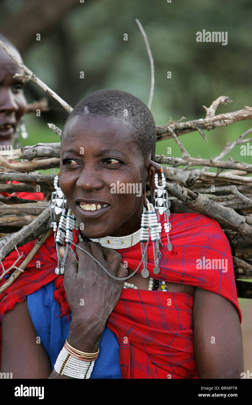 Massai Frau mit Brennholz auf dem Rücken Stockfoto