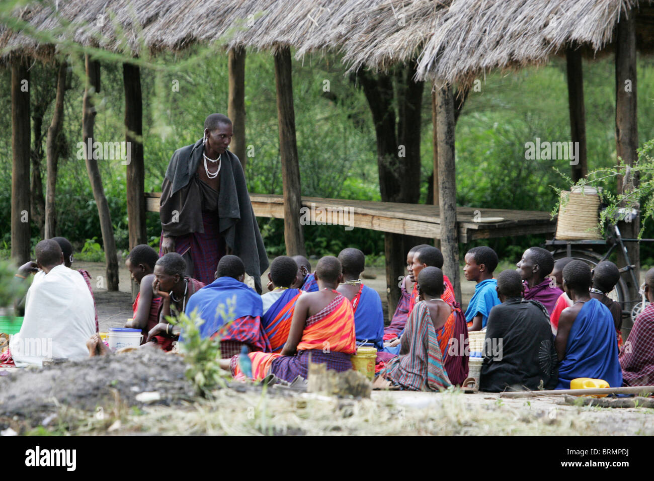 Maasai Dorfbewohner versammelten sich auf dem Boden in Vorbereitung eines Stammes Rituals Stockfoto