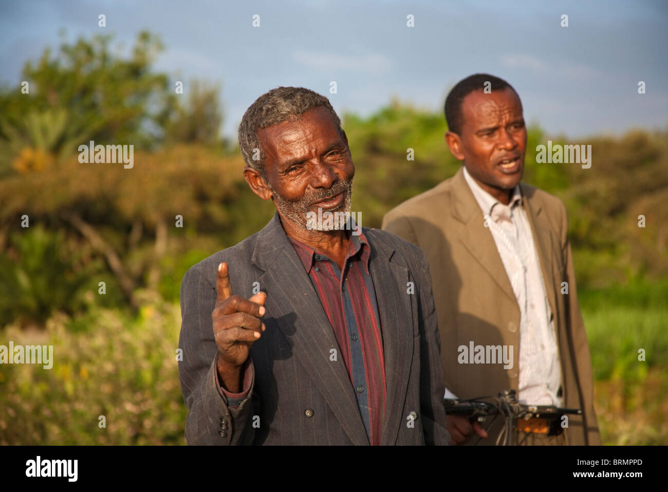 Ein freundlicher älterer Mann wird angehalten, um zu chatten während des Gehens auf das Ufer des Sees Awassa am Abend Stockfoto