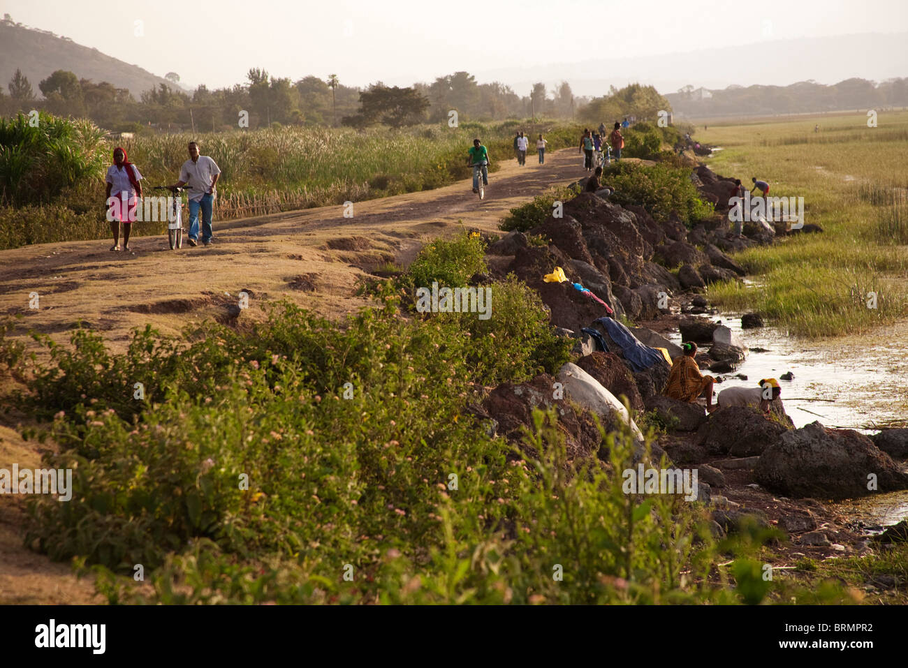 Einheimische Pendler entlang einem Deich am Ufer des Sees Awassa am Abend Stockfoto
