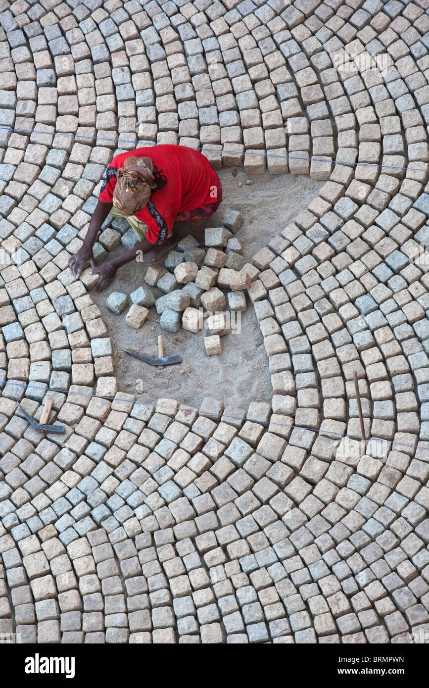 Draufsicht eines Arbeitnehmers Verlegung ein Kopfsteinpflaster Steinpflaster in eine Technik gelernt während der Kolonialzeit von italienischen Handwerkern Stockfoto