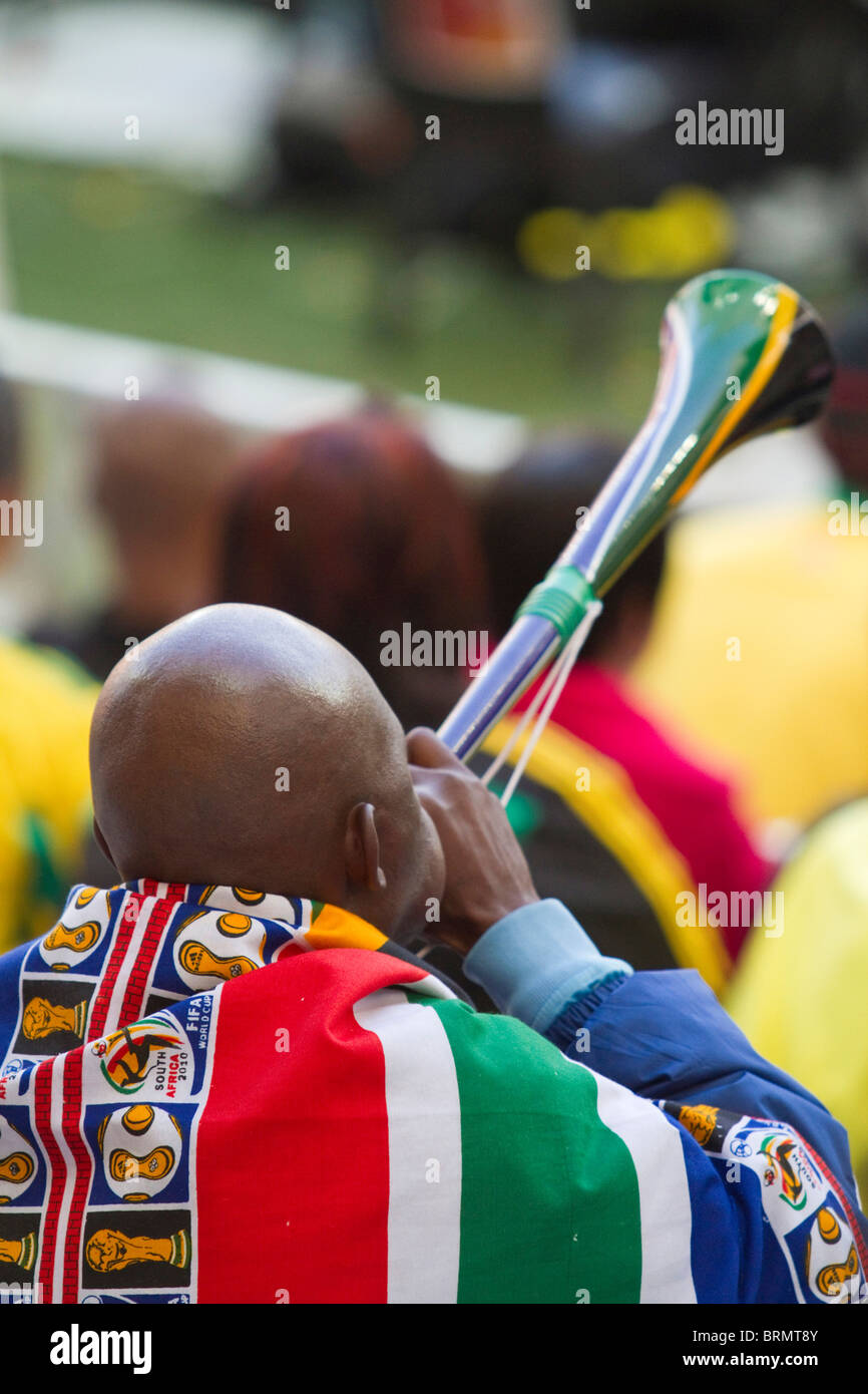 Rückansicht des ein Fußball-Fan drapiert in einem South African World Cup Fahne weht eine Vuvuzela während der WM 2010 Stockfoto
