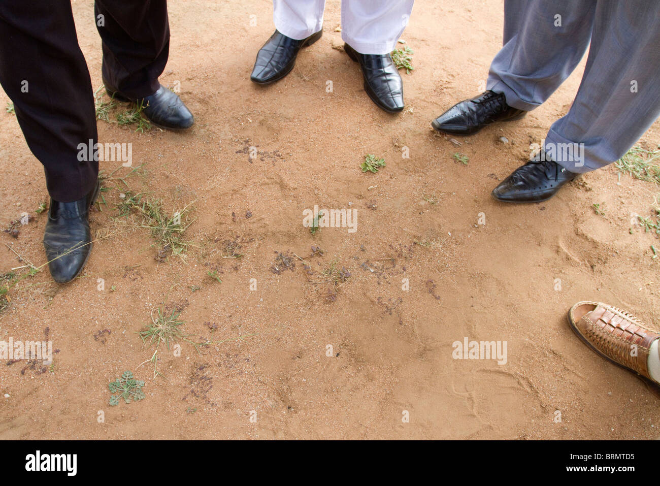 Die Füße von einer Gruppe von afrikanischen Geschäftsleuten im Kreis stehen, bei einem Website-treffen im ländlichen Südafrika Stockfoto