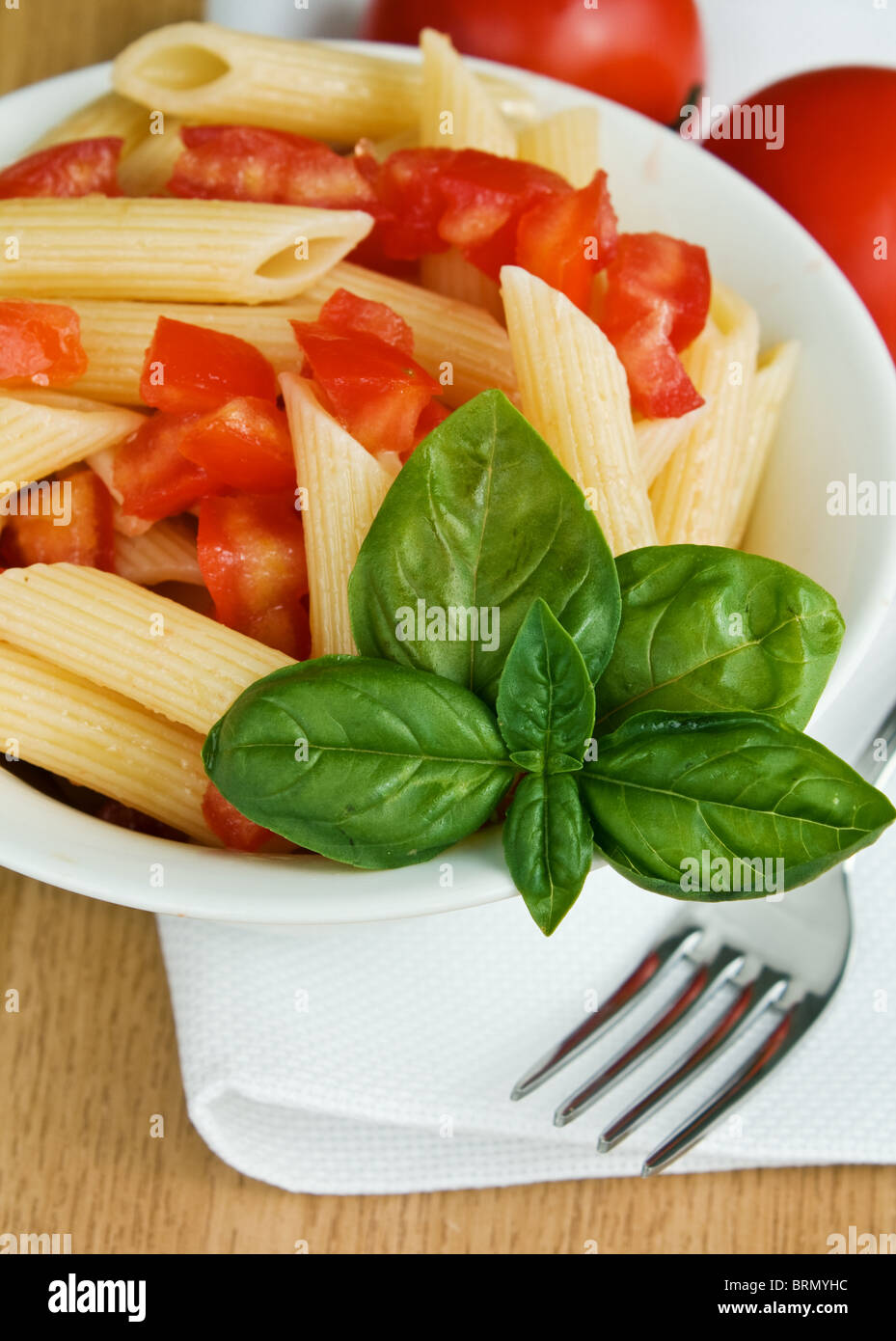 Italienische Pasta mit Tomaten und Basilikum auf dem Tisch Stockfoto