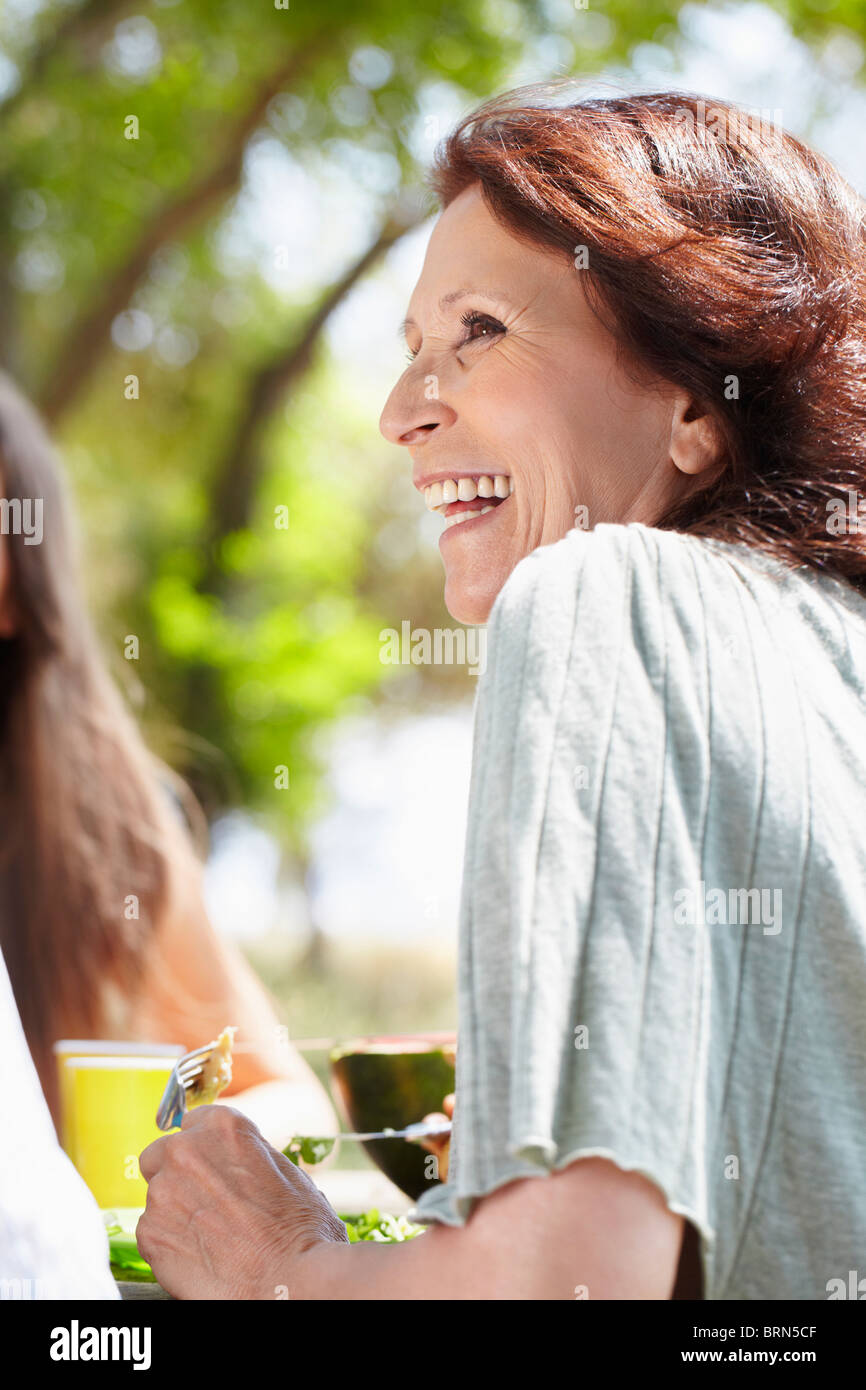 Lächelnde ältere Frau bei Picknick Stockfoto