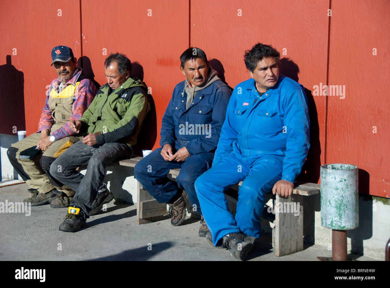 Grönland, Qaqortoq. Süd-Grönland größte Stadt mit fast 3.000 Einwohnern. Einheimische Männer außerhalb Fischmarkt eine Pause. Stockfoto