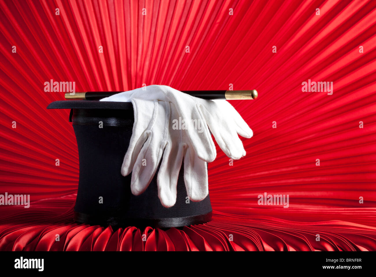 Zauberers Zylinderhut, Zauberstab und Handschuhe auf roten Vorhang Stockfoto
