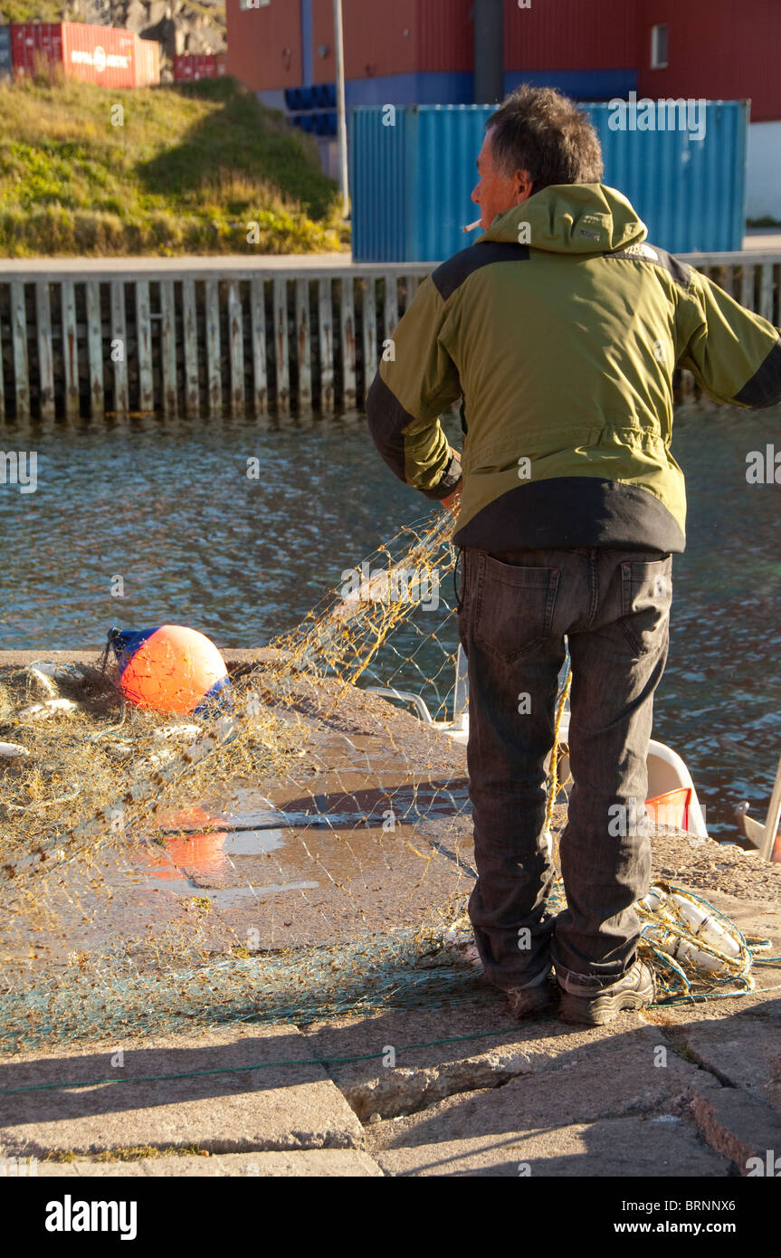 Grönland, Qaqortoq. Süd-Grönland größte Stadt mit fast 3.000 Einwohnern. Lokale Fischer am Pier waschen Netze. Stockfoto