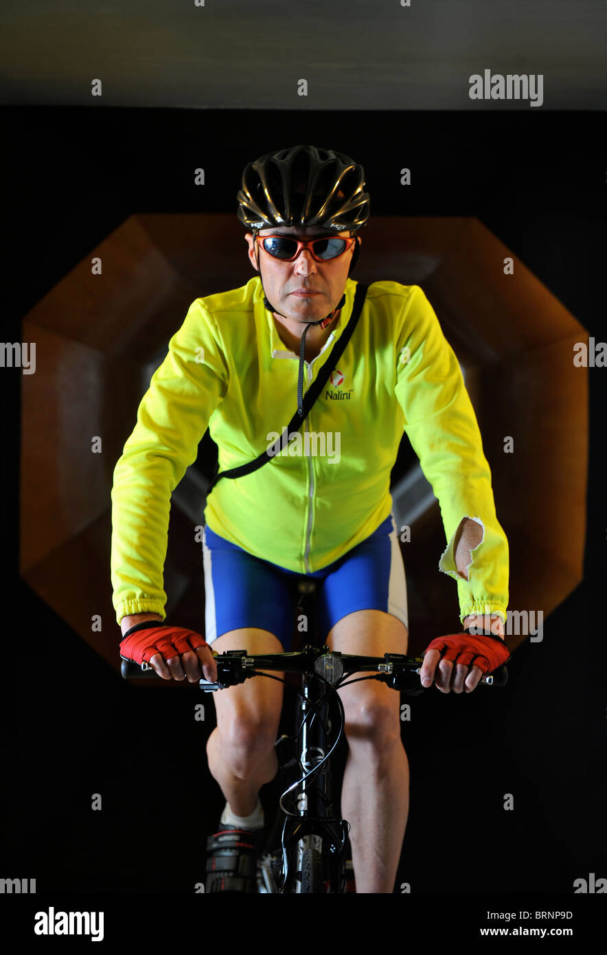 Ein Test-Radfahrer fährt ein Rennrad in einem Windkanal-Experiment für Radsportbekleidung und Racing-Fahrrad-design Stockfoto