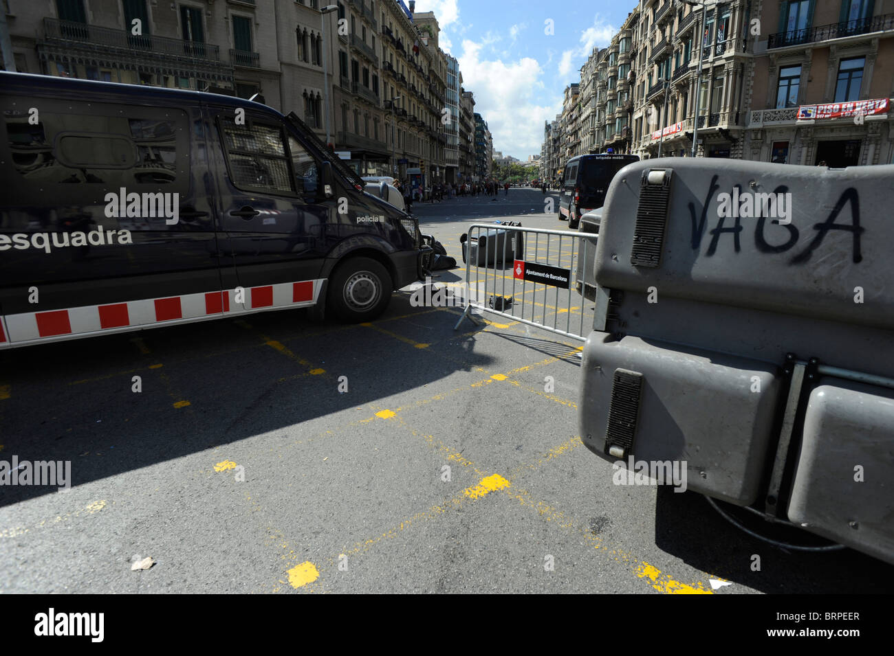 Ein Polizeiwagen bricht durch eine Barriere von Containern bei Zusammenstößen in der Stadt Barcelona während des Generalstreiks in Spanien. Stockfoto