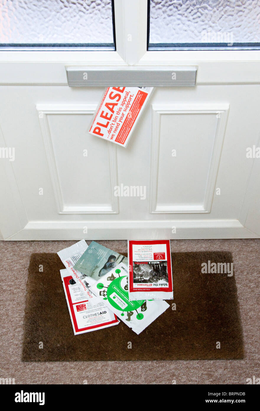 Junk-Mail geliefert in Briefkasten auf Fußmatte Stockfoto