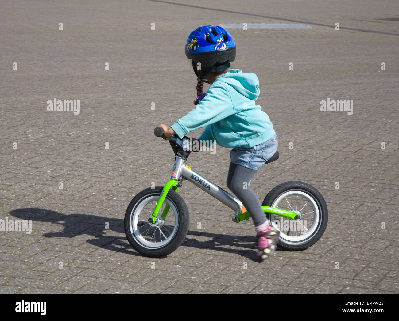 Kleines Mädchen trägt einen blauen Helm mit dem kleinen Fahrrad Radsport hautnah Stockfoto