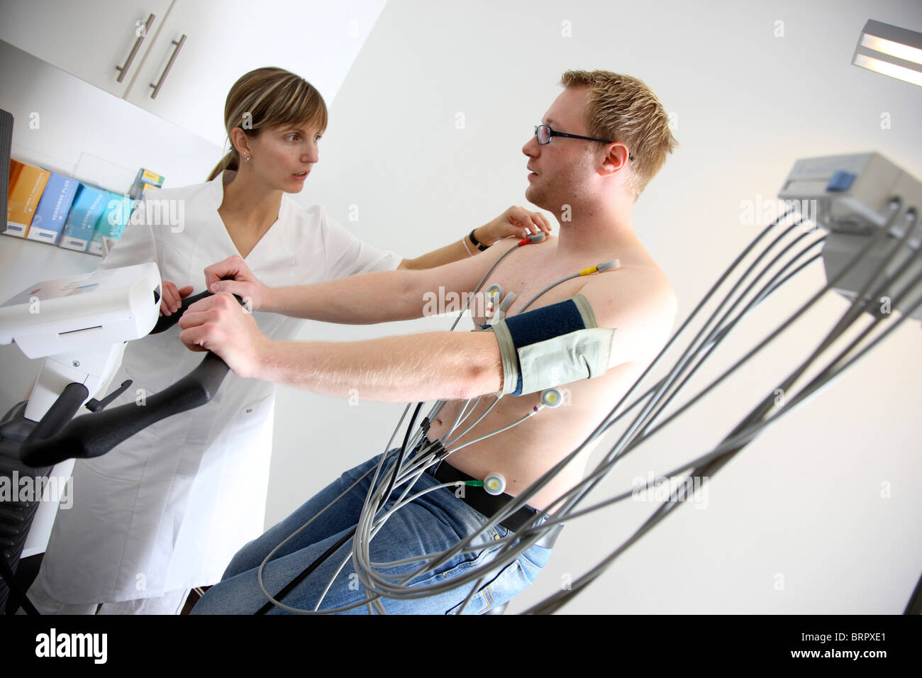Arztpraxis, präventiver Check-up eines Patienten.  Übung Übung EKG, die Echokardiographie, EKG-Aufzeichnung auf einem Cardio-Fahrrad. Stockfoto