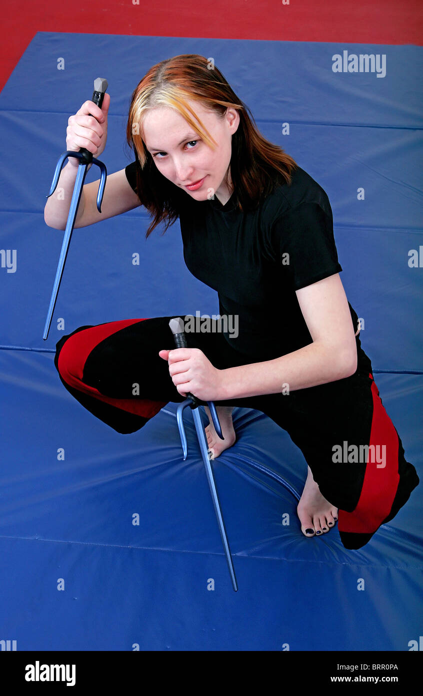 konzentrierte sich attraktive weibliche Mma Student mit Sai Waffen bereit, roten, weißen und blauen Einstellung zu kämpfen Stockfoto