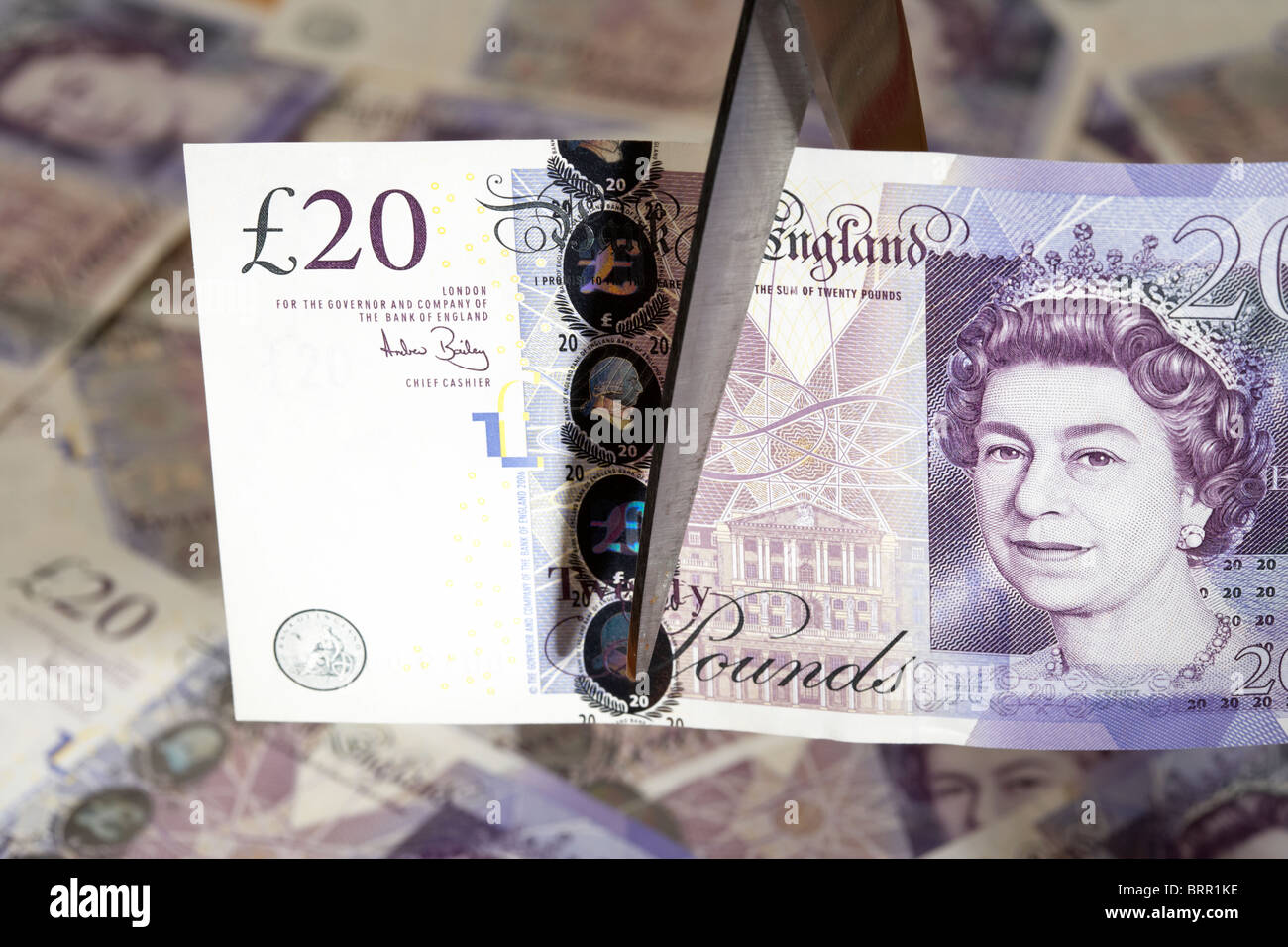 Stapel von zwanzig Pfund Sterling Banknoten mit zwanzig Pfund Hinweis Schnitt mit einer Schere in Großbritannien, Stockfoto