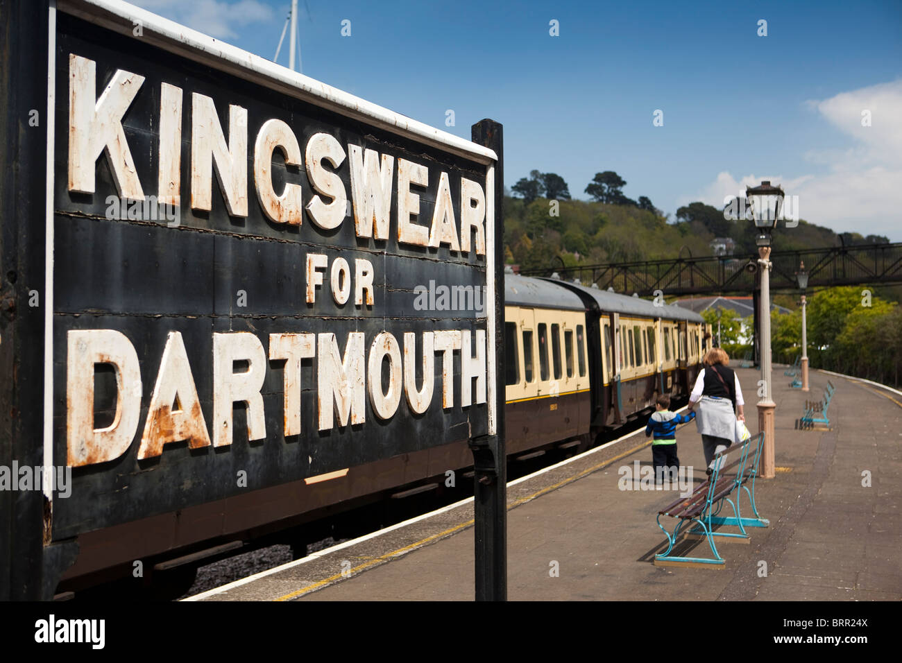 Großbritannien, England, Devon, Kingswear Bahnsteig, Dampf Zugpassagiere zu Fuß vorbei an Dartmouth-Schild Stockfoto