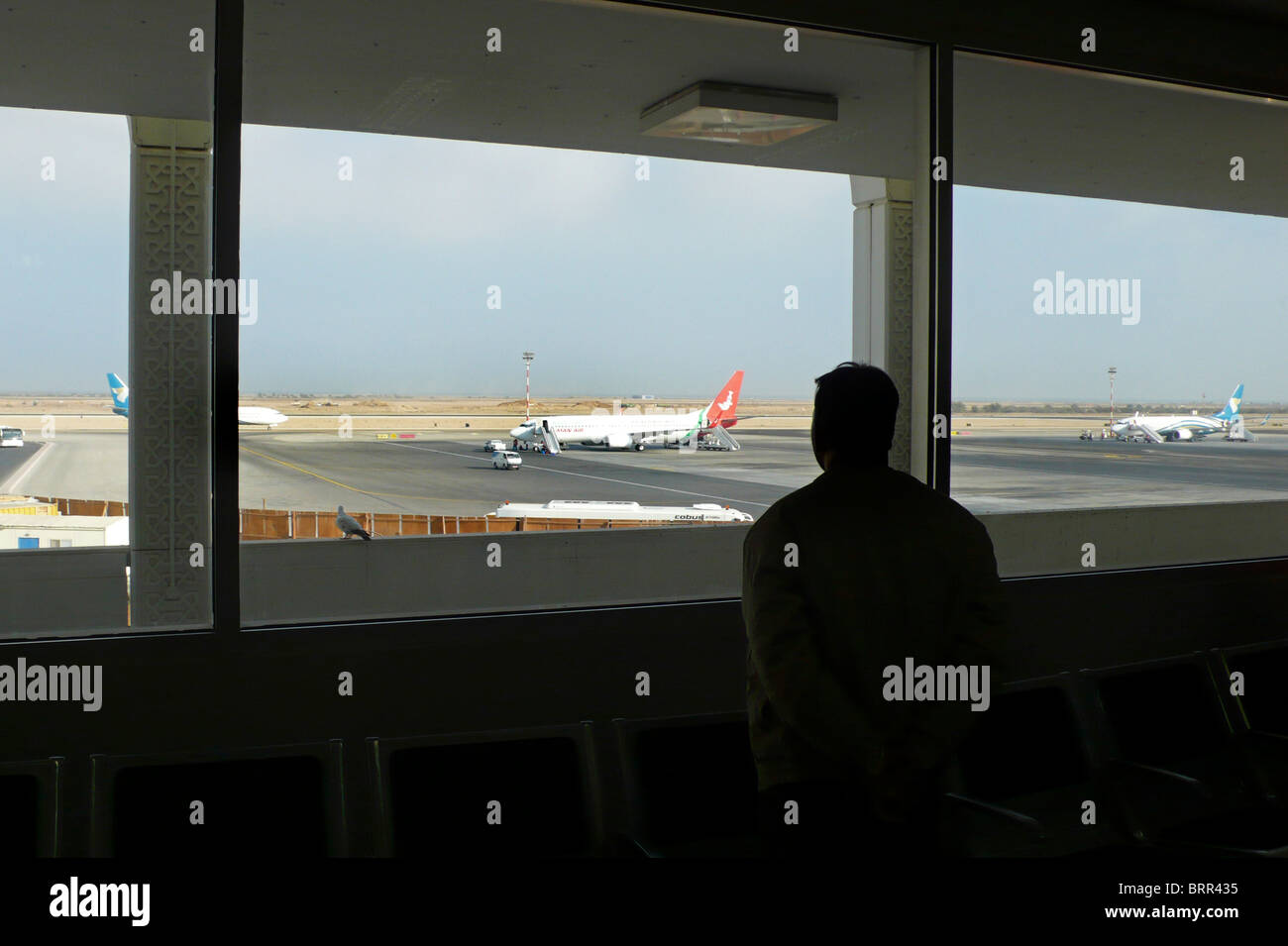 Mann, Blick durch ein Fenster am Flughafen Stockfoto
